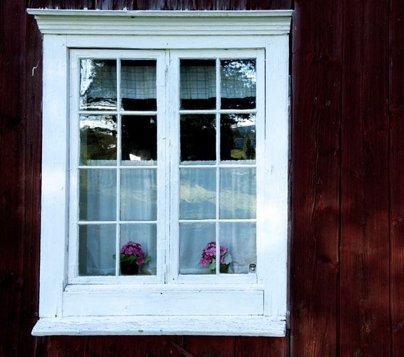 Window on cabin with red wood exterior