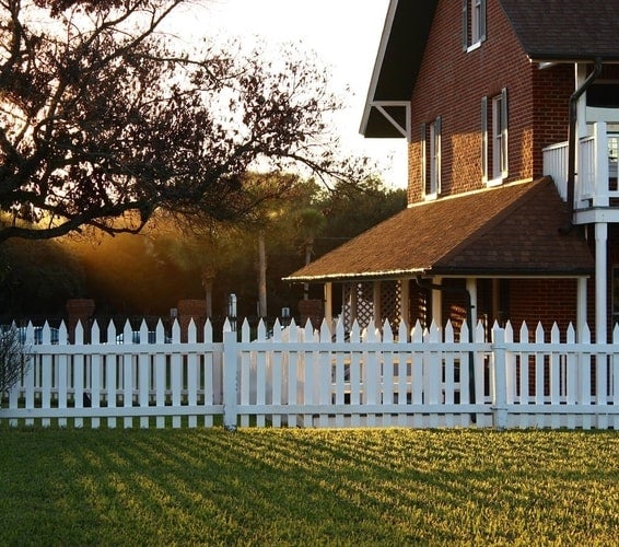 Sun breaking through trees and brown Georgia cottage